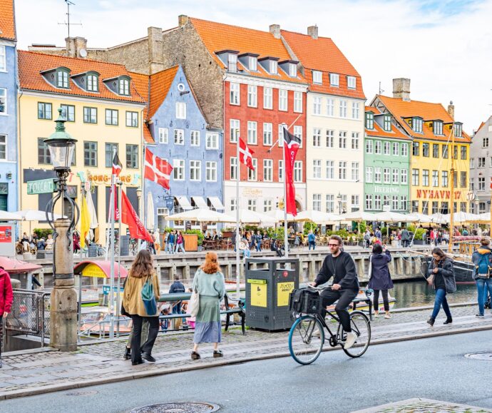 Widok na zabytkową zabudowę Kopenhagi, na pierwszym planie piesi i rowerzyści