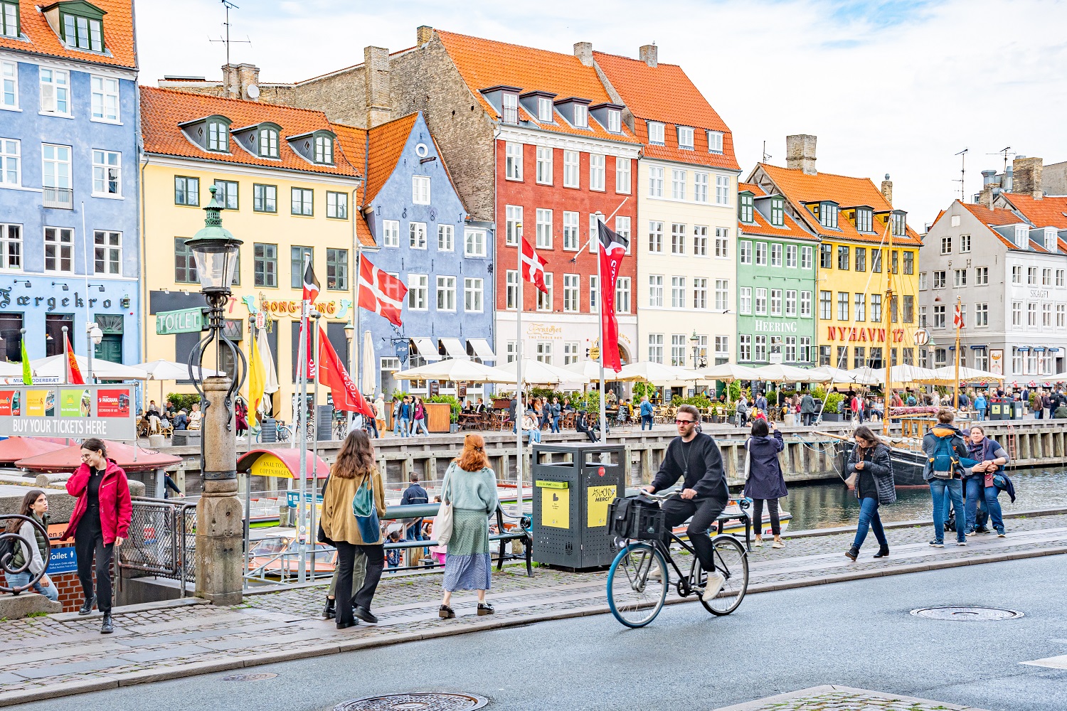 Widok na zabytkową zabudowę Kopenhagi, na pierwszym planie piesi i rowerzyści